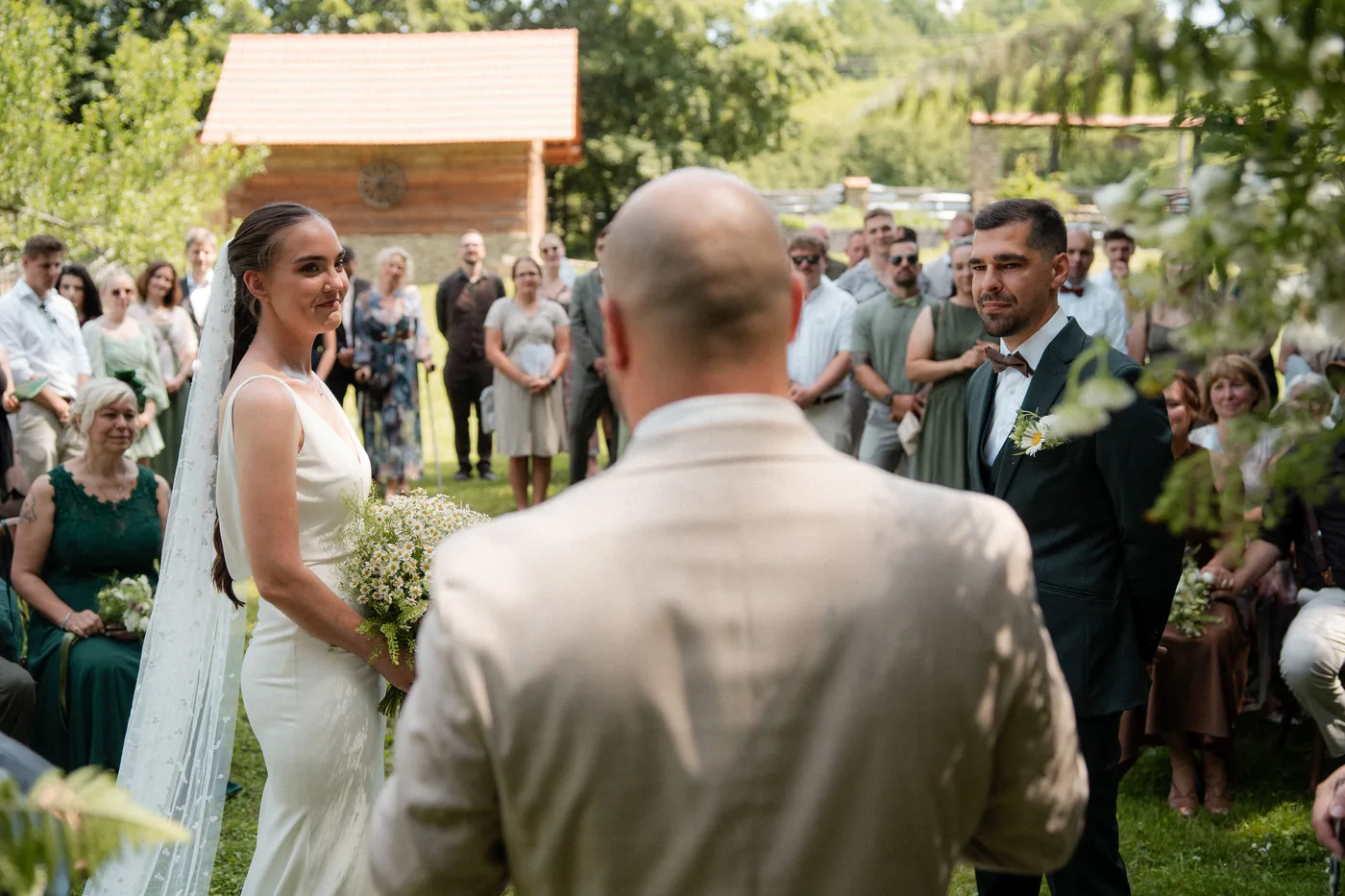 A bride walking towards the ceremony with guests standing on both sides